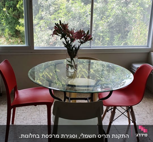 שולחן זכוכית עגול עם כיסאות אדומים